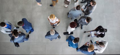 Birds eye view looking down on a group of office workers standing talking to each other