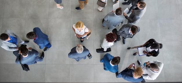 Birds eye view looking down on a group of office workers standing talking to each other