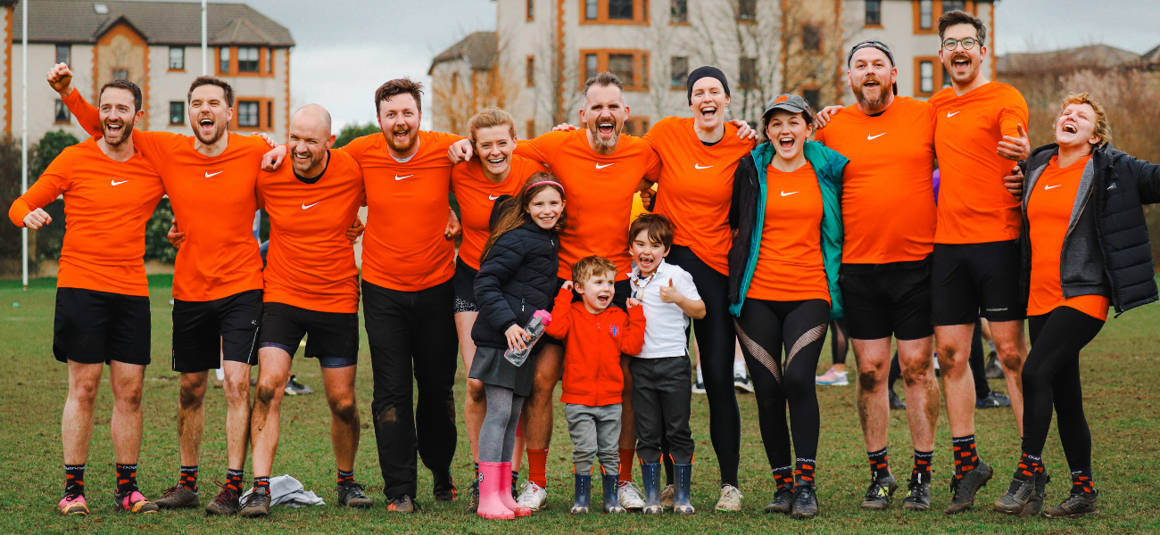 Dayshape touch rugby players cheer in orange tops after the tournament